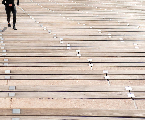 female athlete running up and down steps interval training wearing cw-x gear